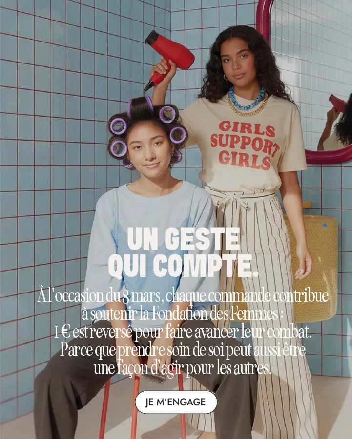 Femme avec bigoudis assise pendant qu’une autre lui sèche les cheveux pour la campagne Myriam K Paris Journée des Femmes.