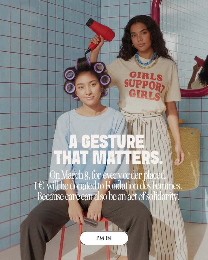 Woman with hair rollers while another dries her hair in a beauty salon scene for the Myriam K Paris Women’s Day campaign.