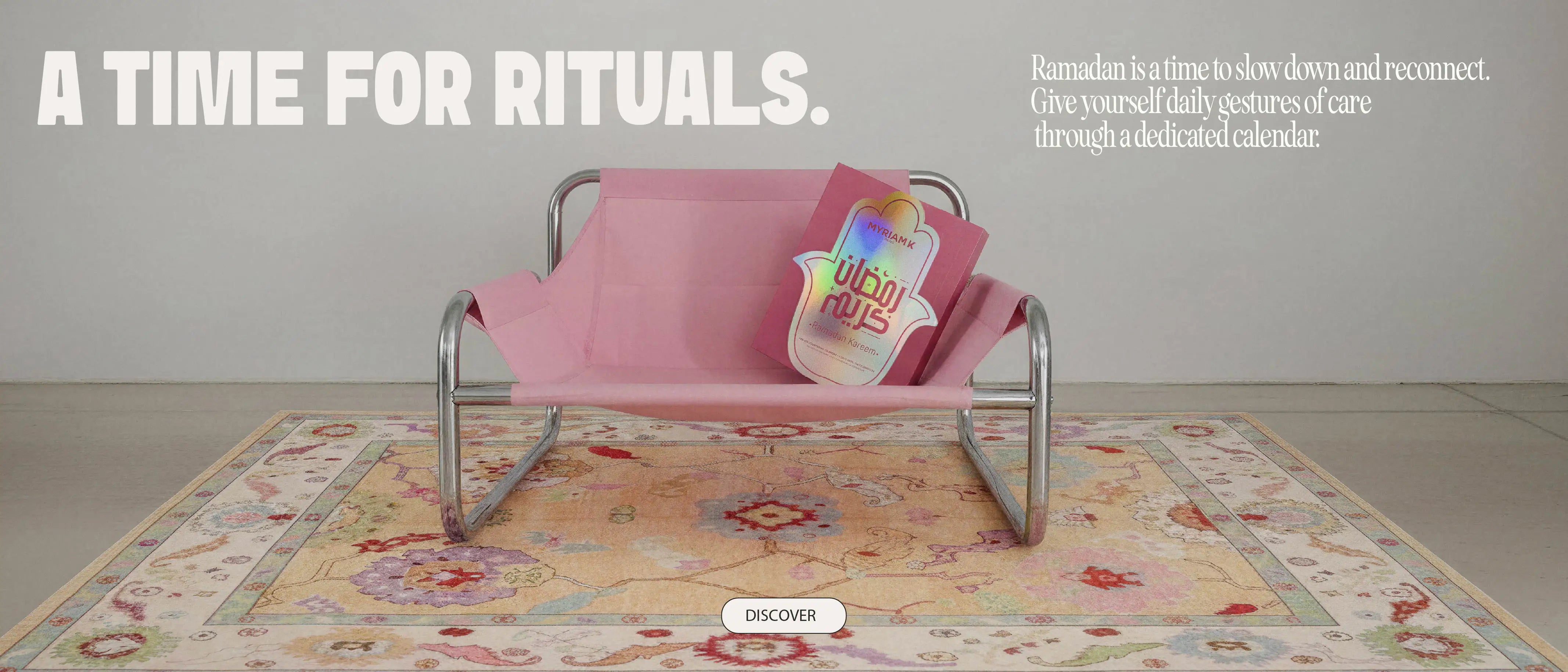 Pink bench featuring the Myriam•K Paris Ramadan ritual calendar placed on a decorative rug, symbolizing calm, self-care, and reconnection during Ramadan.