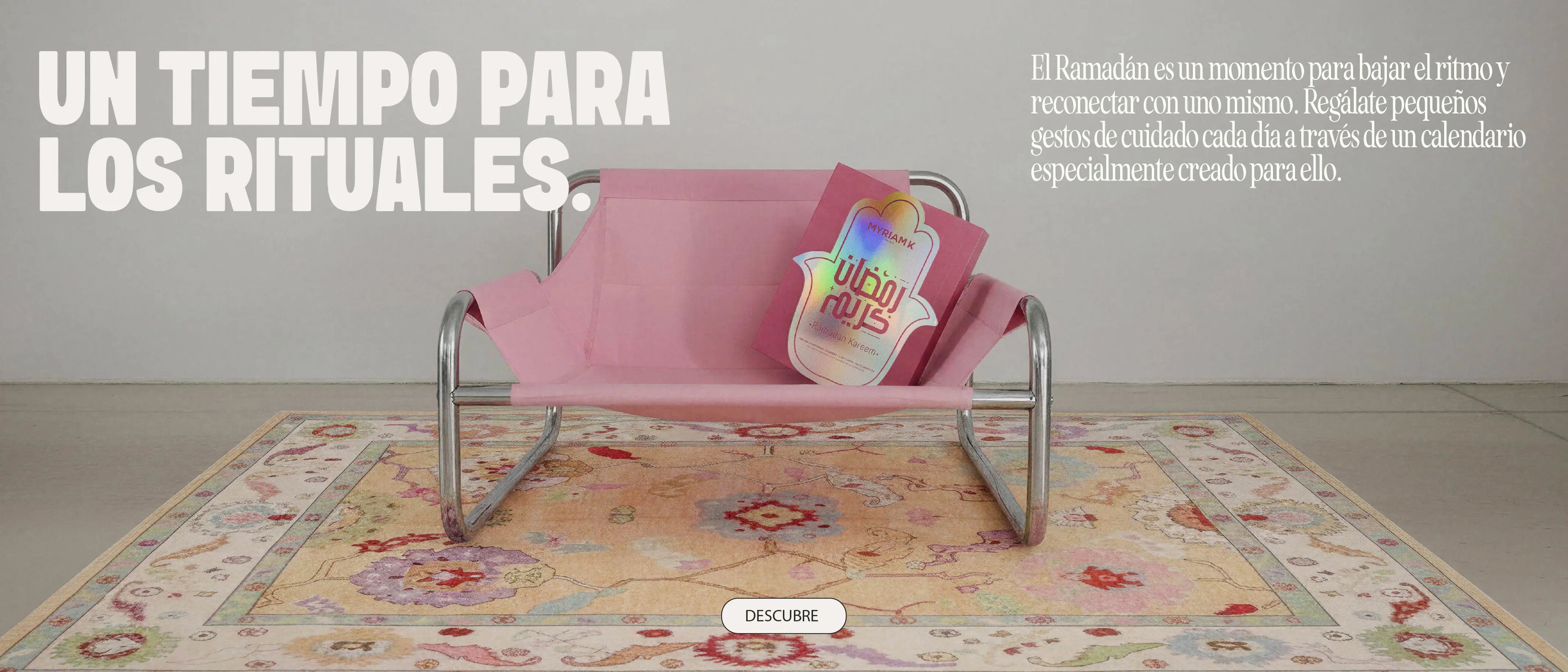 Banco rosa con calendario de rituales de Ramadán Myriam•K Paris sobre una alfombra decorativa, representando un momento de calma, autocuidado y reconexión durante el Ramadán.